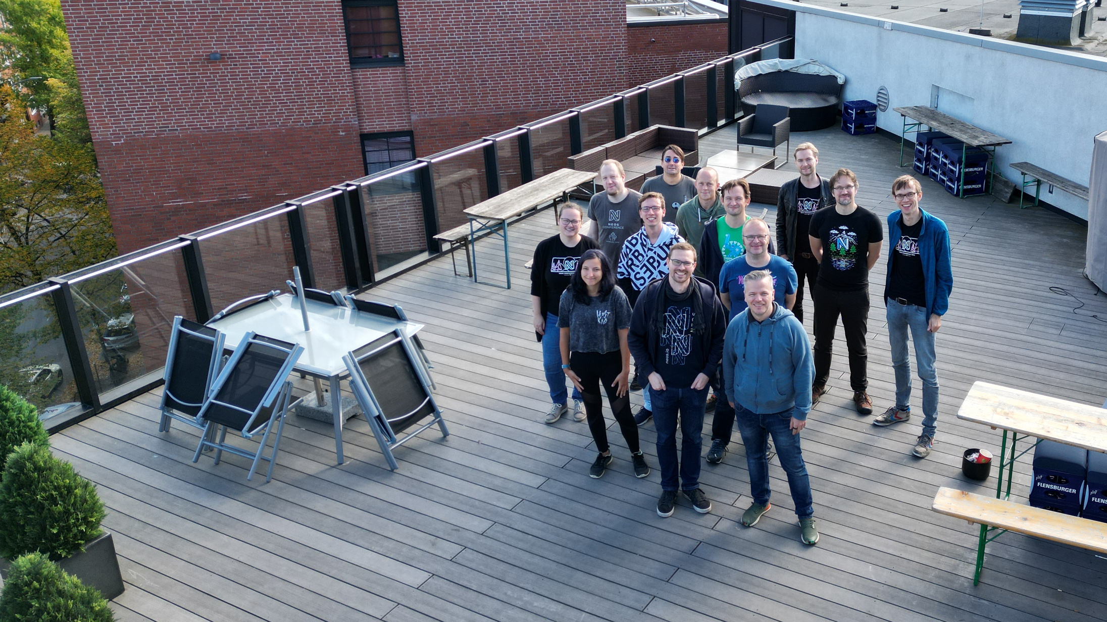 A drone photo of eleven people who where at the Neos Sprint. They are standing on the roof terrace of the building where Sitegeist is located.