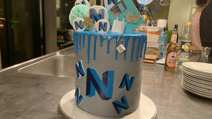 Cake with blue and grey icing and Neos logos