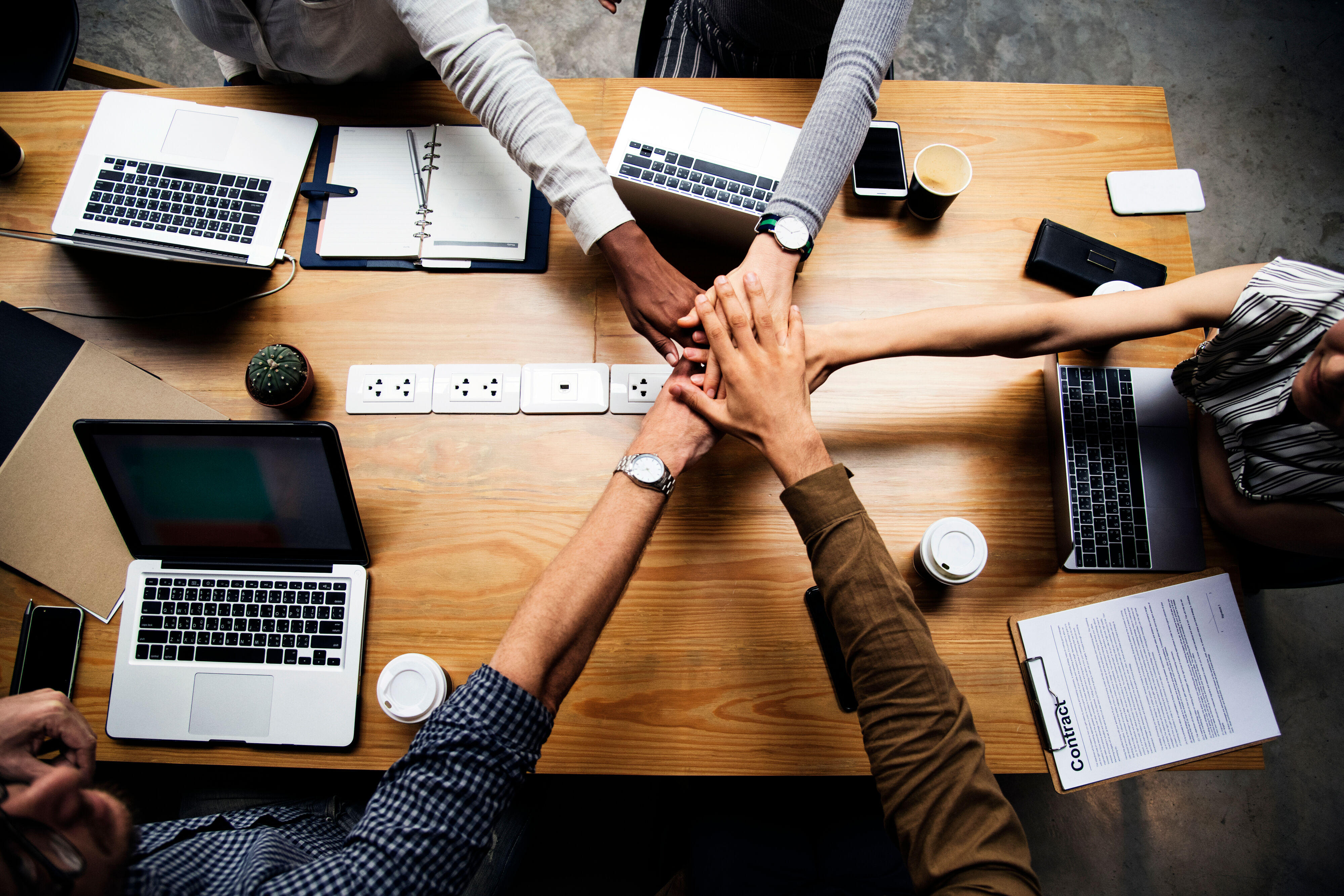 Team of people stacking hands