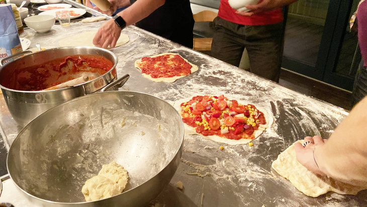 self-made pizza on kitchen counter with flour